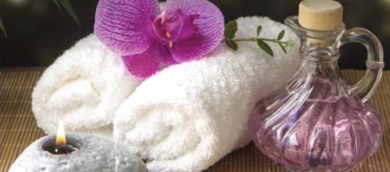 Rolled towels, orchid and massage oil